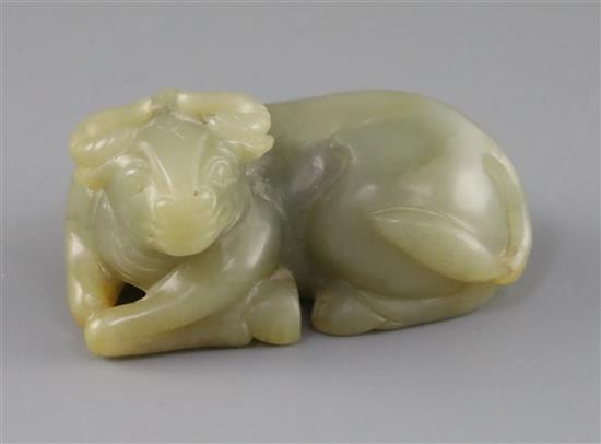 A Chinese celadon and russet jade figure of a recumbent ox, late Qing dynasty, L.8cm